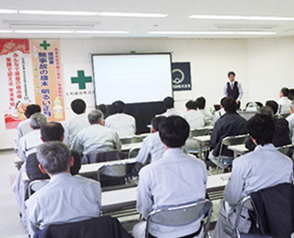 講習会で前を向いて座る参加者たち、スクリーンを使って講師が講義を行っている様子